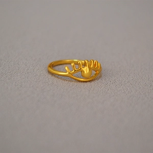 Detailed macro view of vintage eye-shaped hollow gold ring with eyelash design
