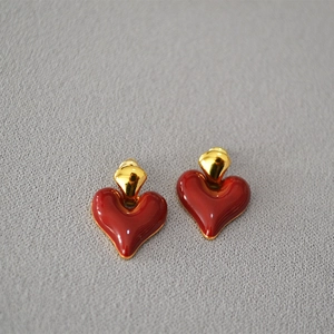 Close-up of vintage heart earrings with deep red enamel glaze and gold metal finish