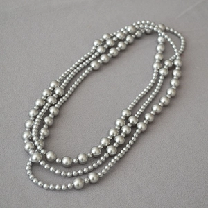 Detailed view of triple-layered silver grey pearl necklace with gradient size design
