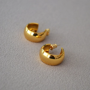 Modern gold thick C-shaped hoop earrings with a high-polished mirror finish for women