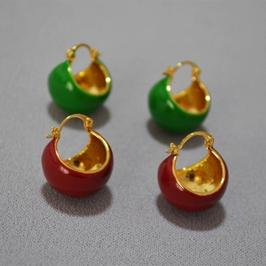 Détail de boucles d'oreilles en émail rouge et vert avec intérieur plaqué or poli