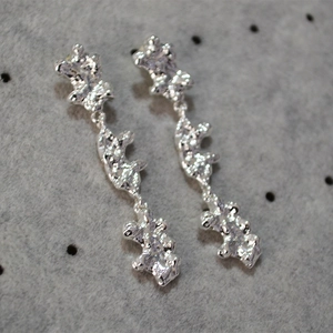 Detail of silver drop earrings featuring a unique three-tier liquid lava texture design
