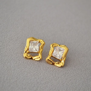 Retro brass gilded earrings with rectangular zircon and irregular lava texture on fabric