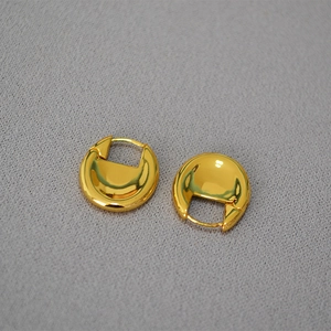 Detail of chunky oval hoop earrings in gold plated brass with polished finish