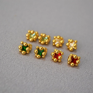 Macro view of square multi-color zircon earrings with gold plating and ornate metal beadwork