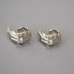 Exaggerated silver C-shape earrings with hammered texture and sparkling zircon