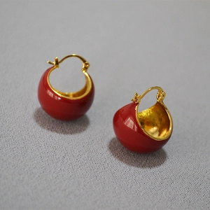 Détail de boucles d'oreilles demi-sphère en émail rouge et laiton doré