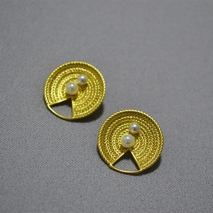 Vue détaillée des boucles d'oreilles vintage en laiton doré avec perles et texture tissée