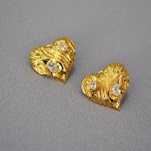 Vintage gold heart earrings with zircon stones and wrinkled metal texture in a 45-degree view