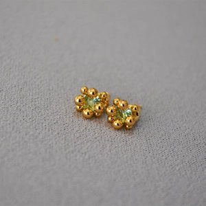 Macro shot of 18K gold flower bud earrings with light green square zircon stones
