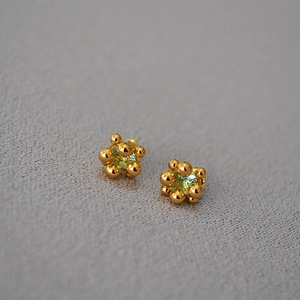 Close-up of golden flower bud earrings with sparkling zircon and 925 silver needle