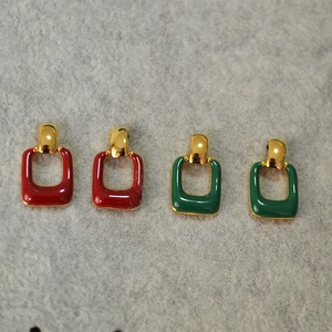 Detailed macro of vintage enamel geometric earrings in emerald green and retro red hues