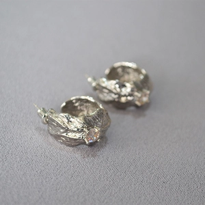 C-shaped silver earrings with natural textured metal finish and sparkling zircon stones