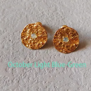Detail of gold studs with October light blue-green gemstone and hammered texture