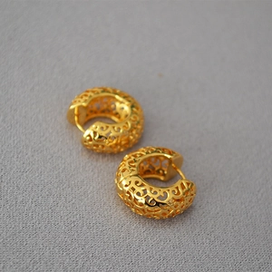 Vintage hollow gold hoops with intricate scroll patterns and polished C-shaped design