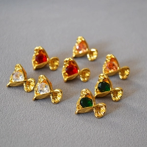 Macro detail of fan-shaped gold earrings with colorful zircon stones in various colors