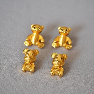 Macro shot of 925 silver needle bear earrings with detailed gold striped texture