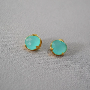 Detailed shot of sky blue faceted gemstones in golden 925 silver four-claw settings