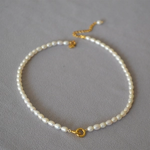 Detail of freshwater rice pearls and golden double ring clasp on elegant choker necklace