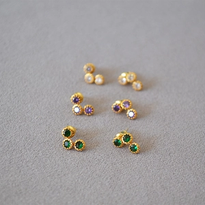 Macro shot of three-stone cluster earrings in gold finish with zircon crystals
