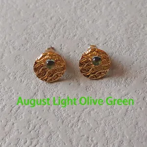 Detail of gold studs with water-ripple texture and August peridot green gemstone