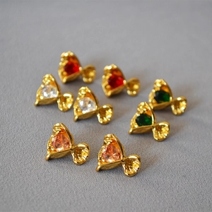Macro detail of bouquet-shaped stud earrings with colorful cubic zirconia and gold finish