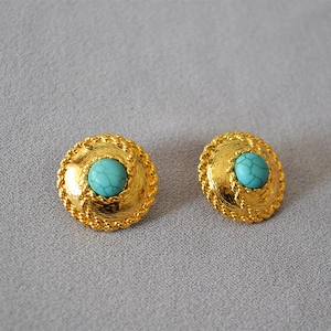 Detailed macro of gold woven disc earrings with center turquoise blue gemstone inlay