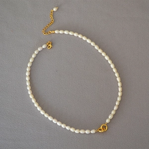 Detail of freshwater rice pearls and gold interlocking double rings on a choker necklace