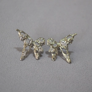 Macro shot of liquid metal butterfly earrings with clear sparkling zircon inlay