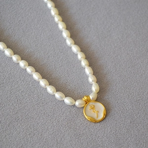 Macro detail of French retro rose relief pendant with textured gold and freshwater pearls