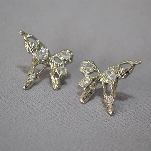 Macro shot of liquid metal texture butterfly earrings with sparkling cubic zirconia crystals