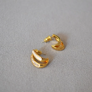 Golden C-shaped earrings with white enamel and rectangular zircon inlay details