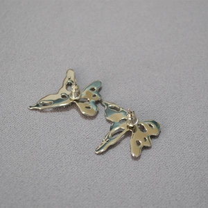 Back view of silver liquid butterfly earrings with hollow texture and silver needle post