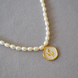 Baroque freshwater pearl necklace with a vintage gold floral hexagon pendant charm