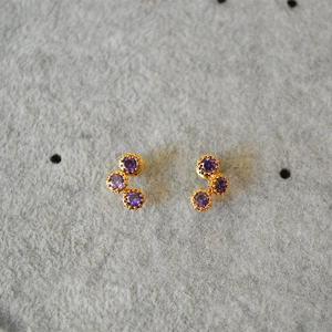 Elegant gold earrings featuring three curved purple zircons in a delicate claw setting