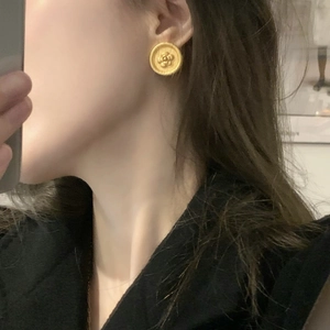 French vintage brass gold camellia coin earrings on model with retro textured finish