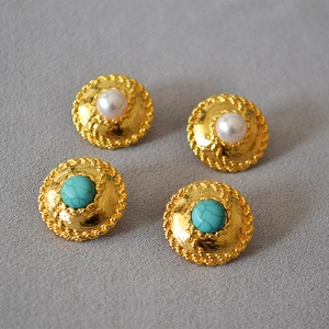 Detail of vintage gold earrings with woven texture, faux pearls and turquoise stones