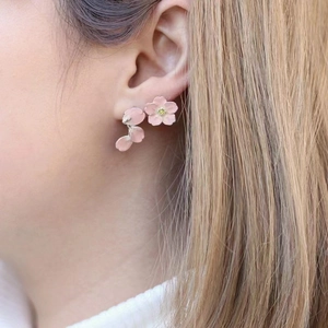 Romantic pink cherry blossom enamel earrings with yellow zircon centers worn by model