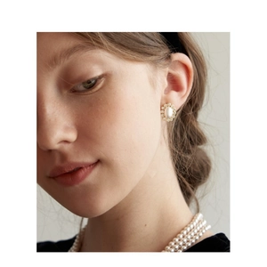 Detail of vintage flower cluster pearl earrings and triple layer pearl necklace