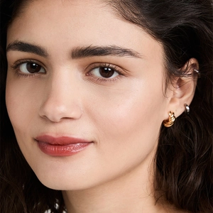 Golden twisted rope hoop earrings with croissant design on model for elegant style