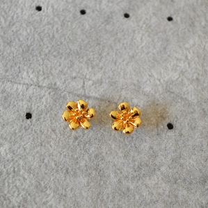 Macro detail of gold-plated 925 silver camellia earrings with 3D floral petals