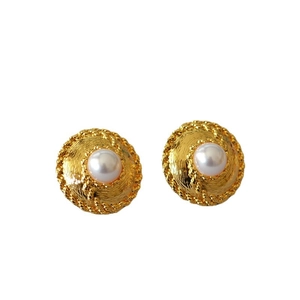 Vintage gold disc earrings with center pearl and radiant texture on white background
