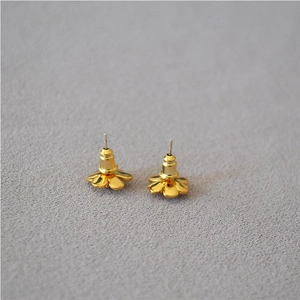 Close-up of golden camellia flower earrings back view showing secure bullet clutch backs