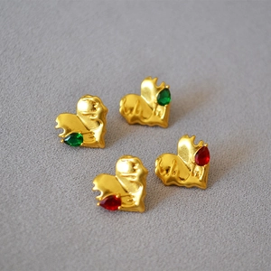 Detail of heart-shaped gold plated earrings with molten texture and teardrop crystals