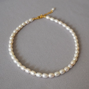Dettaglio collana di perle d'acqua dolce con chiusura dorata e catenella regolabile