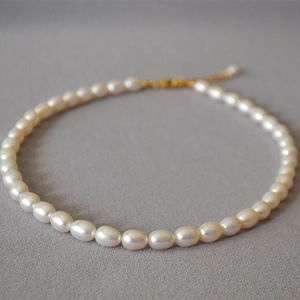 Dettaglio della collana di perle d'acqua dolce con chiusura dorata e texture fine