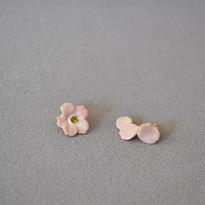 Detail of pink enamel cherry blossom earrings with yellow crystal centers on gold base