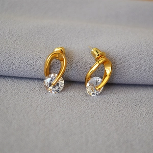 Macro shot of gold-plated 925 silver stud earrings with sparkling round cubic zirconia