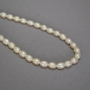Elegante collana di perle d'acqua dolce a chicco di riso con riflessi rosa su tessuto