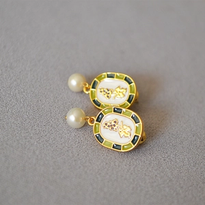 Detailed close-up of handmade grape enamel earrings with a white pearl drop